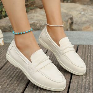 Beige classic round toe slip-on loafers with a decorative strap detail.