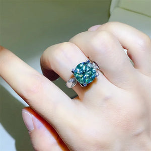 Silver ring with a large green moissanite solitaire and sculpted band.