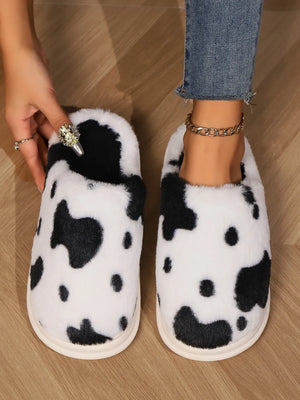 Cow print faux fur house slides in black and white, with plush lining.