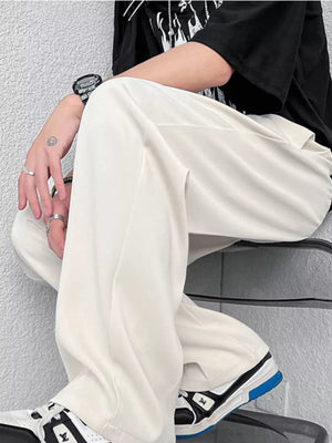Cream wide-leg casual pants with a relaxed fit, styled with sneakers.