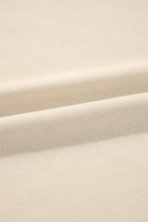 Cream sweatshirt fabric detail showing soft texture and subtle ribbing.