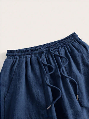 Navy linen wide-leg drawstring trousers with elastic waist and pockets.