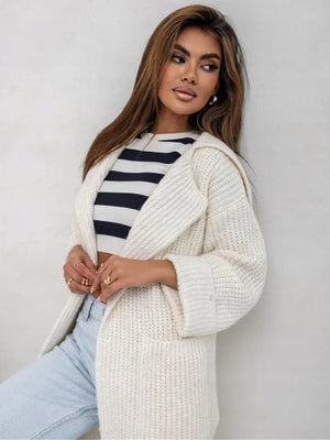 Cream oversized knit lapel cardigan with pockets, worn open over a striped top.