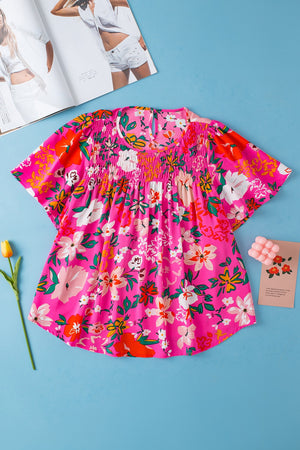 Hot pink floral smocked yoke flutter sleeve blouse with keyhole neckline.