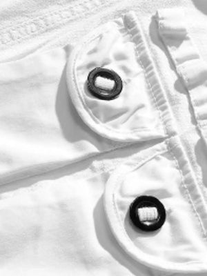 White men's cargo shorts detail with black button closures on flap pockets.