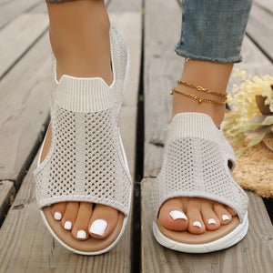 Ivory open-toe sandals with breathable knit fabric and ankle cuff detail.