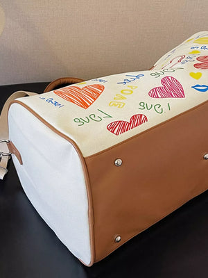 Vibrant canvas duffel bag with colorful hearts and "love" print, brown trim, and adjustable strap.