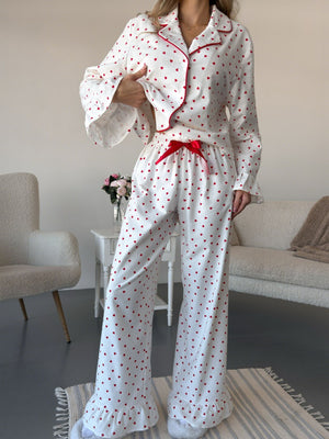 White cotton pajama set with red hearts, button front top and wide leg pants with ruffle hem.