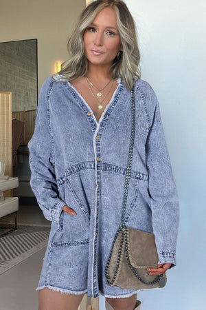 Acid wash denim shirtdress with raw hem, button front, and V-neck.