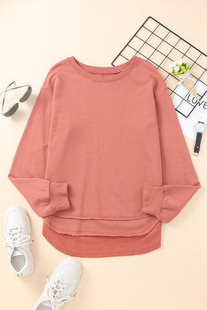 Rose pink sweatshirt with asymmetric hemline and raw edge detail.
