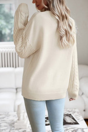 Cream cable-knit sleeve relaxed fit sweater with crew neck and ribbed cuffs.