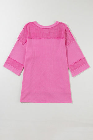 Fuchsia pink waffle knit top with raw seam details and a relaxed fit.