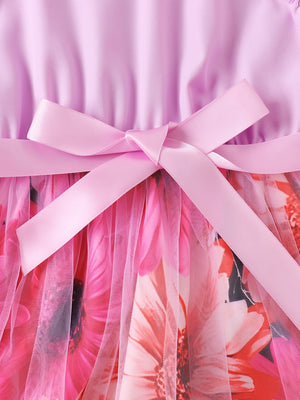 Toddler dress with pink bow detail and floral print skirt overlayed with pink tulle.