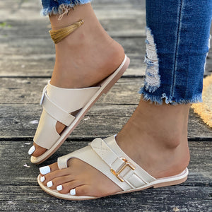 Beige toe loop flat sandals with buckle detail and crisscross straps.