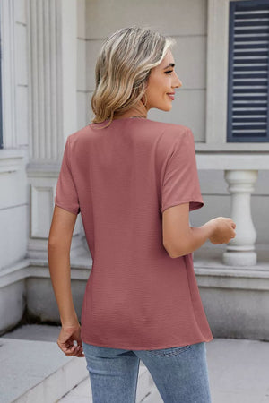 Draped crossover short sleeve top in dusty pink with textured fabric.