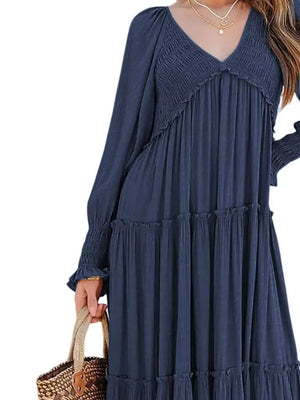 Blue smocked V-neck tiered maxi dress with ruffled tiers and smocked cuffs.
