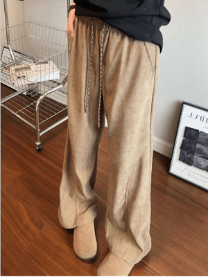 Men's beige corduroy drawstring pants with a relaxed fit.