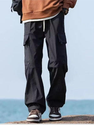 Black relaxed fit cargo pants with flap pockets and drawstring waist.