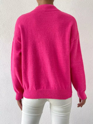 Fuchsia pink mock neck knit sweater with dropped shoulders and ribbed cuffs and hem.