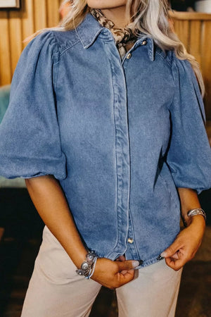 Denim maternity blouse with voluminous puff sleeves, collared neckline, and button-down front.