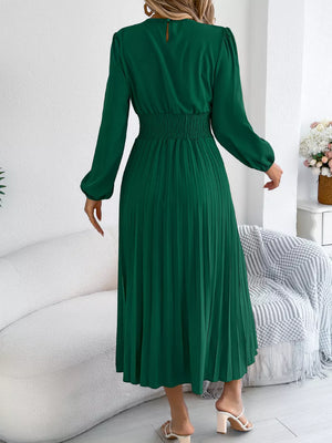 Green midi dress with long sleeves, smocked waist, and pleated skirt.