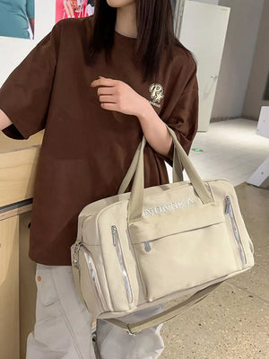 Beige canvas duffel bag with embroidered NONGKA logo, zippered pockets, and adjustable strap.