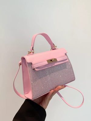 Pink glitter textured mini crossbody bag with gold hardware and top handle.