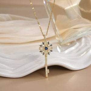 Gold-plated key pendant necklace with blue and white crystals, delicate design