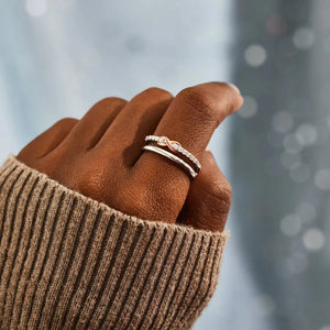 Silver infinity knot trio ring set with pave stones on a finger.