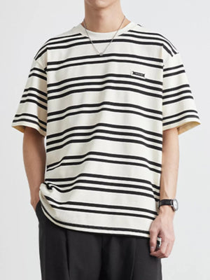 Men's striped cotton crew neck tee in apricot with black stripes and a small chest logo.