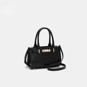 Black crocodile-embossed mini tote handbag with gold hardware and crossbody strap.