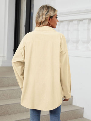 Oversized corduroy shirt jacket in cream with buttoned cuffs and a relaxed fit.