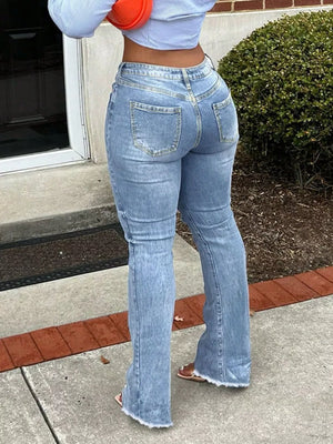 Light blue distressed flare jeans with raw hem and whiskering detail.