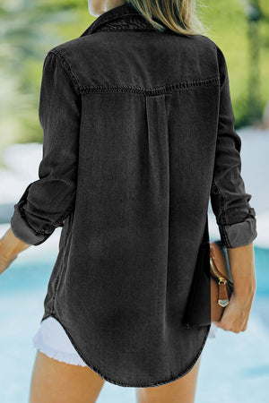 Relaxed black denim shirt with buttoned cuffs and a curved hem.