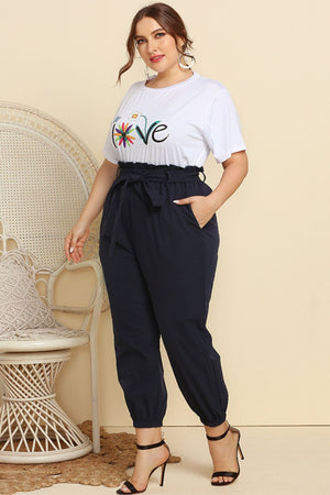 Paperbag waist lounge pants in navy with a tie belt and cuffed ankles.