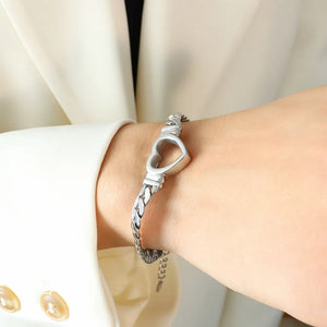 Silver curb chain bracelet with a hollow heart charm, 18K gold-plated.