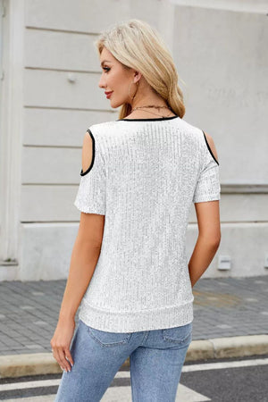 White sequin cold shoulder blouse with black trim and short sleeves.