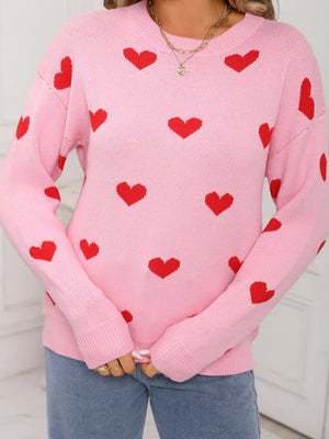 Pink acrylic knit sweater with a red heart print, crew neck, and long sleeves.