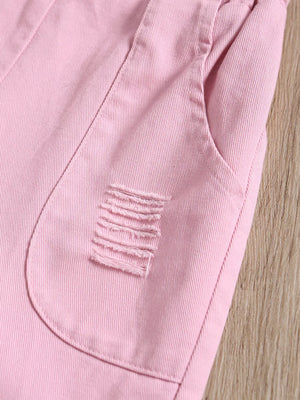 Pink distressed denim overalls for baby girls with frayed pocket detail.