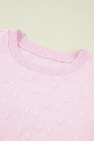Blush pink loungewear set with embossed bow pattern and crew neck.