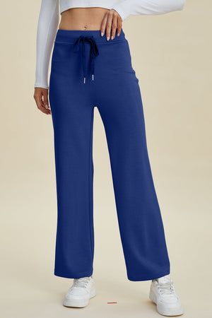 Blue wide leg lounge pants with drawstring waist and white sneakers
