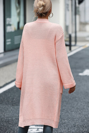 Longline knit cardigan in watermelon pink with pockets and cuffed sleeves.