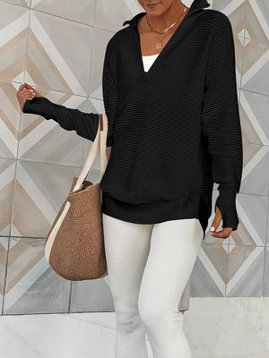 Black ribbed knit pullover with funnel neck and quarter zip, long sleeves with thumbholes.
