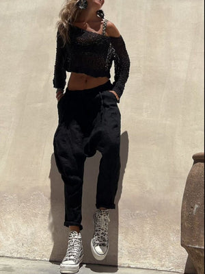 Black asymmetric crochet crop top with off-shoulder detail and long sleeves.