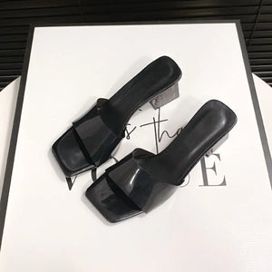 Black lucite heel square toe mules with clear block heel.