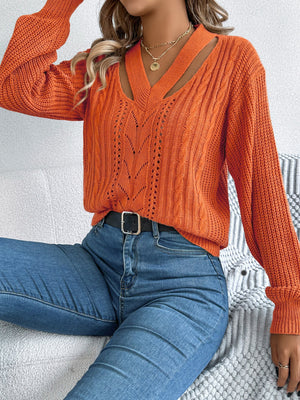 Terracotta cable knit sweater with cutout neckline, long sleeves, and open knit detail.