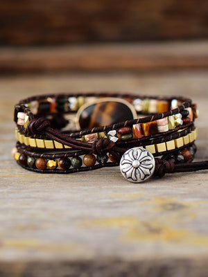 Wrap-around bracelet with tiger's eye beads, leather cords, and silver button closure.
