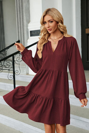 Burgundy textured babydoll mini dress with voluminous sleeves and tiered hem