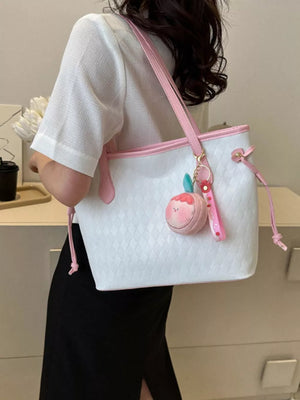 Textured diamond woven tote bag with pink trim and a fruit charm.