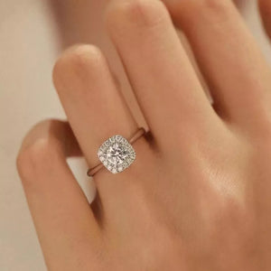 Elegant moissanite and sterling silver ring with cushion-cut center stone and halo.